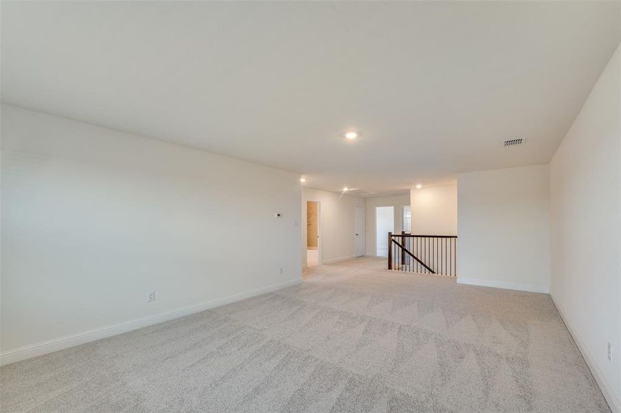 Spare room with light carpet and baseboards