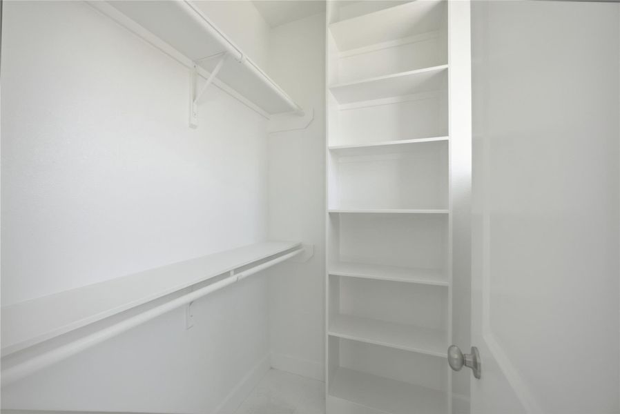 Walk-In Closet for Secondary Bedroom – Custom shelving and generous space make this walk-in closet a dream for organization.