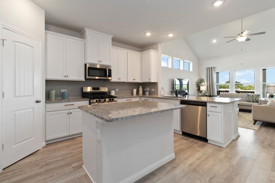 Open-concept kitchen with white cabinets, granite countertops, center island, and stainless steel appliances Open-concept kitchen with white cabinets, granite countertops, center island, and stainless steel appliances