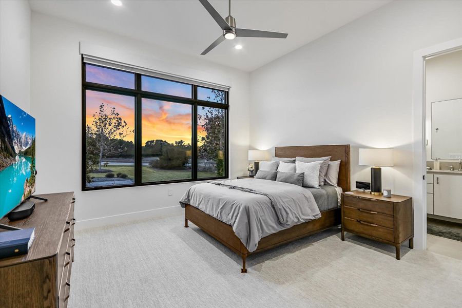 Bedroom featuring light carpet, a ceiling fan, vaulted ceiling, recessed lighting, and connected bathroom Bedroom featuring light carpet, a ceiling fan, vaulted ceiling, recessed lighting, and connected bathroom