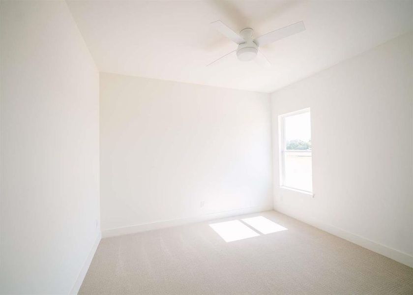 Carpeted empty room featuring ceiling fan