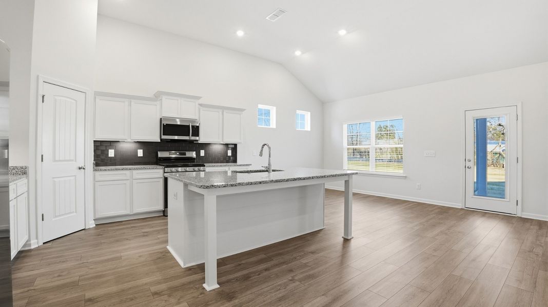 kitchen with granite counter tops, under cabinet lights, pantry, gas range, spacious island (will accommodate 4-bar stools)