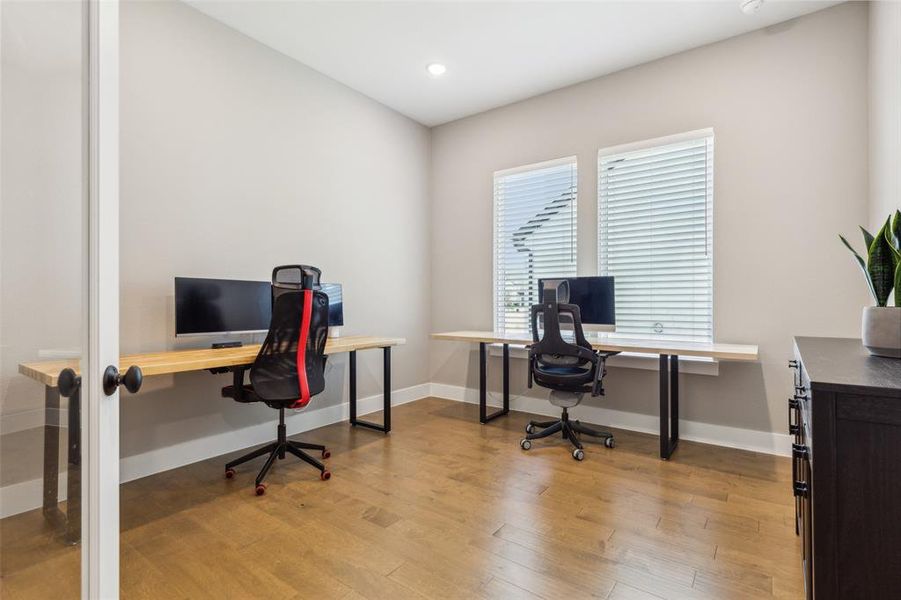 Office space with light hardwood / wood-style flooring