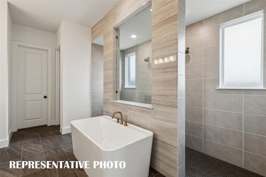 Enjoy a spa like experience every day in our signature bath with double walk through shower and free standing tub.  REPRESENTATIVE PHOTO
