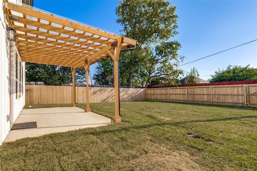 Fenced backyard featuring a pergola and a patio area Fenced backyard featuring a pergola and a patio area
