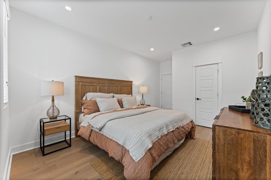 This spacious second-floor primary bedroom exudes modern elegance with its sleek engineered wood flooring that adds warmth and texture underfoot. Soaring high ceilings amplify the sense of openness, allowing natural light to cascade in and highlight the room’s architectural charm. Whether styled with minimalist furnishings or layered with cozy accents, the space offers a serene retreat elevated by its refined finishes and elevated vantage point.