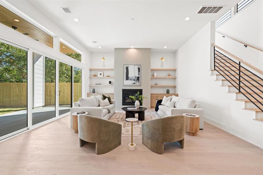 Expansive living room with built in fireplace with a view of the outdoor patio. First floor has 12 foot ceilings! Previous TOMO Homes project.