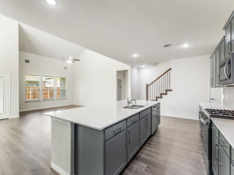 Kitchen with gray cabinetry, dark wood-style flooring, appliances with stainless steel finishes, open floor plan, and recessed lighting