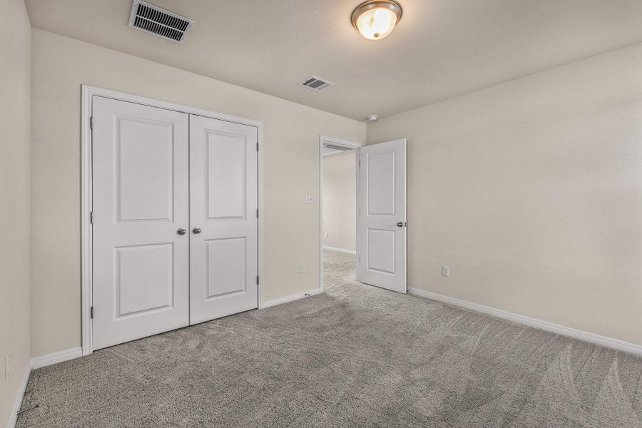 Unfurnished bedroom with carpet flooring and a closet Unfurnished bedroom with carpet flooring and a closet