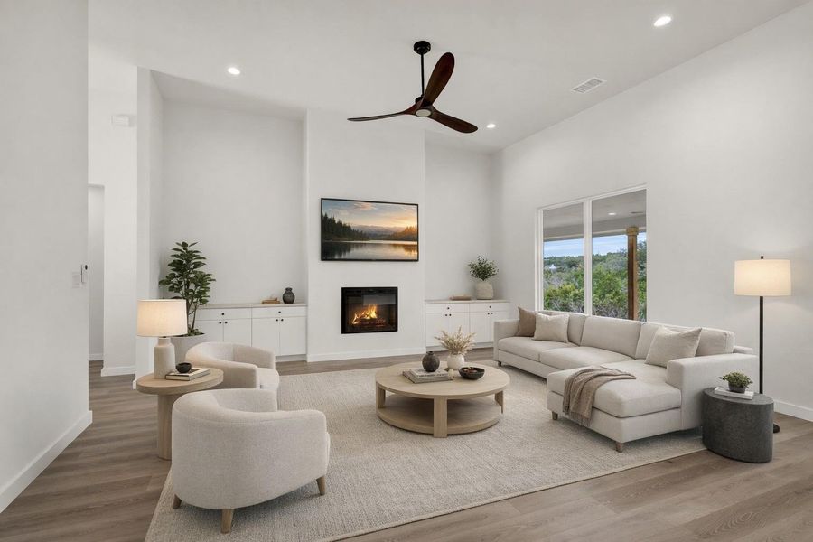 Living room with a glass covered fireplace, wood finished floors, a ceiling fan, and recessed lighting