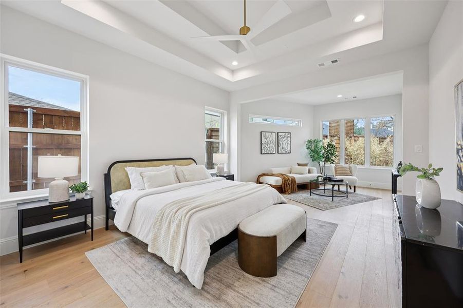 Bedroom featuring recessed lighting, light wood finished floors, a ceiling fan, and a tray ceiling