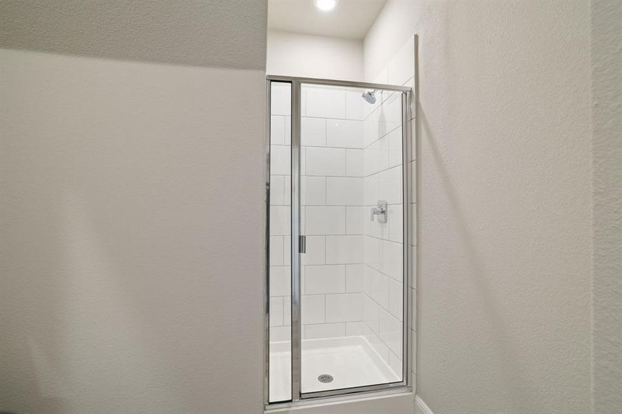 Full bathroom with a textured wall, a stall shower, and recessed lighting Full bathroom with a textured wall, a stall shower, and recessed lighting