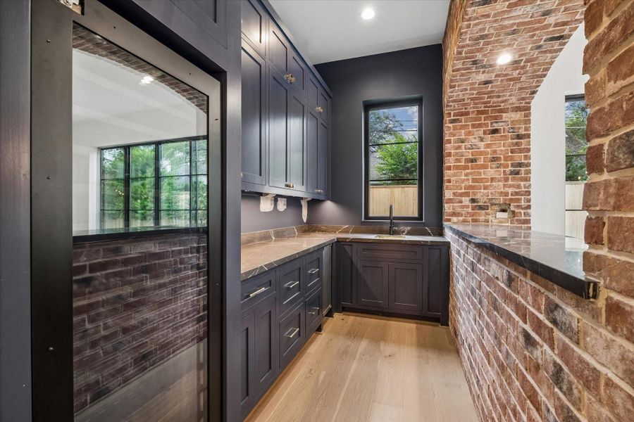 Perfect for entertaining this elegant bar features full-size (to be) paneled wine refrigerator, ice maker and sink.