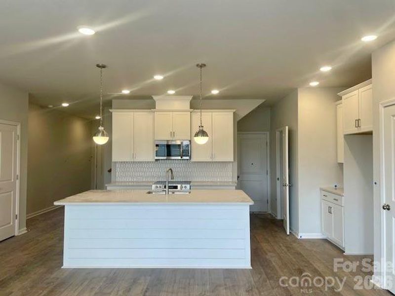 Actual Home - Kitchen features 42" cabinets, soft close doors & drawers, quartz countertops. Oversized island with shiplap wrap. Tile backsplash, pantry has solid shelving. Frigidaire gallery appliances with exhaust venting to the outside. LVP flooring. Home with be complete mid-March- professional photos due 3/13