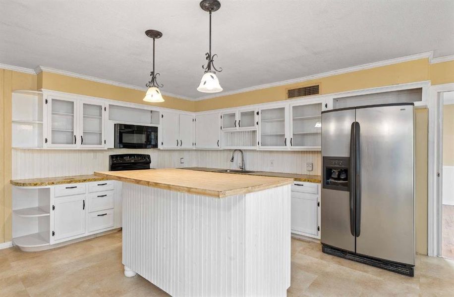 Kitchen featuring open shelves, white cabinetry, butcher block countertops, black appliances, and glass insert cabinets