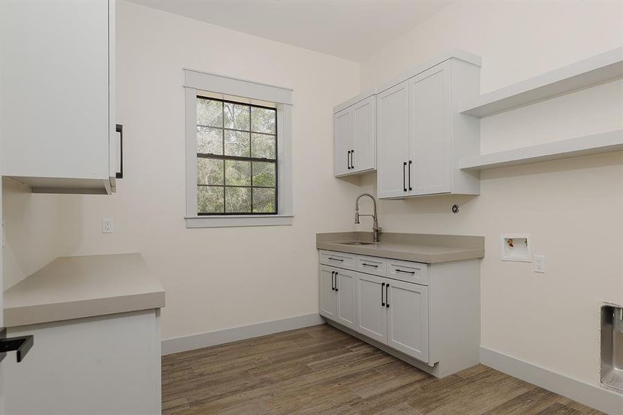 Generous laundry room with shelving and cabinets