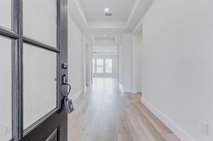 Solid wood 42 inch wide Flemish glass front door, perfect for letting in light and still having privacy.Grand door opens to a wide foyer with white oak luxury vinyl plank floors that flow seamlessly through the living, kitchen, and primary areas. Bright, open, and inviting from the moment you step inside.