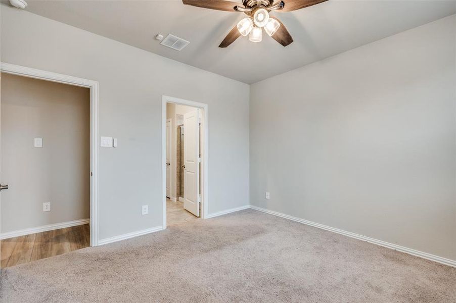 Unfurnished bedroom with light carpet and a ceiling fan