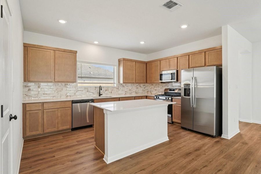 A well-lit kitchen features modern appliances and a central island, perfect for culinary endeavors. A well-lit kitchen features modern appliances and a central island, perfect for culinary endeavors.