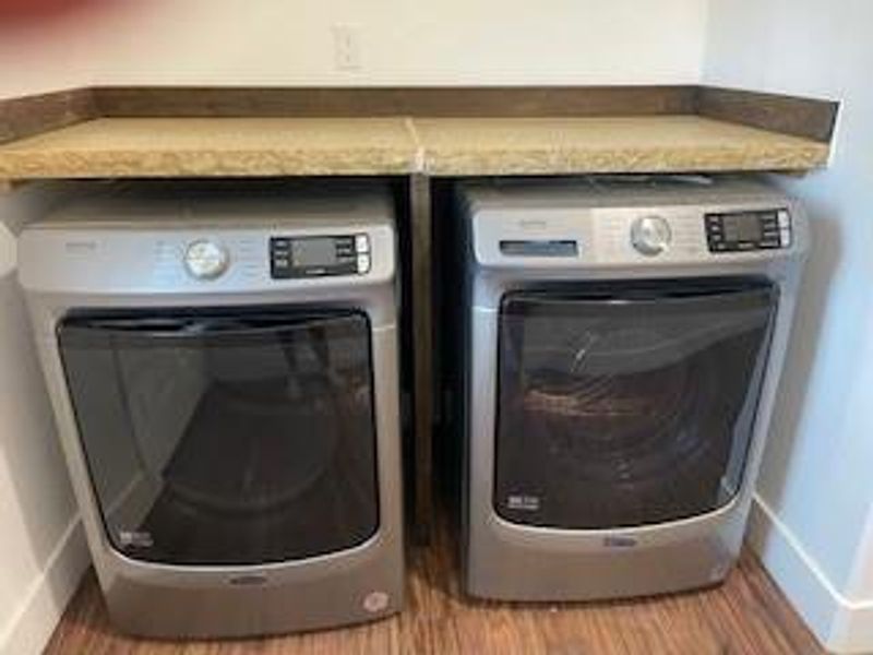 Clothes washing area featuring wood-type flooring and separate washer and dryer