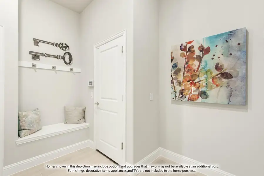 Mudroom entryway with built-in bench, coat hooks, decorative key wall art, and colorful canvas painting on adjacent wall. Mudroom entryway with built-in bench, coat hooks, decorative key wall art, and colorful canvas painting on adjacent wall.