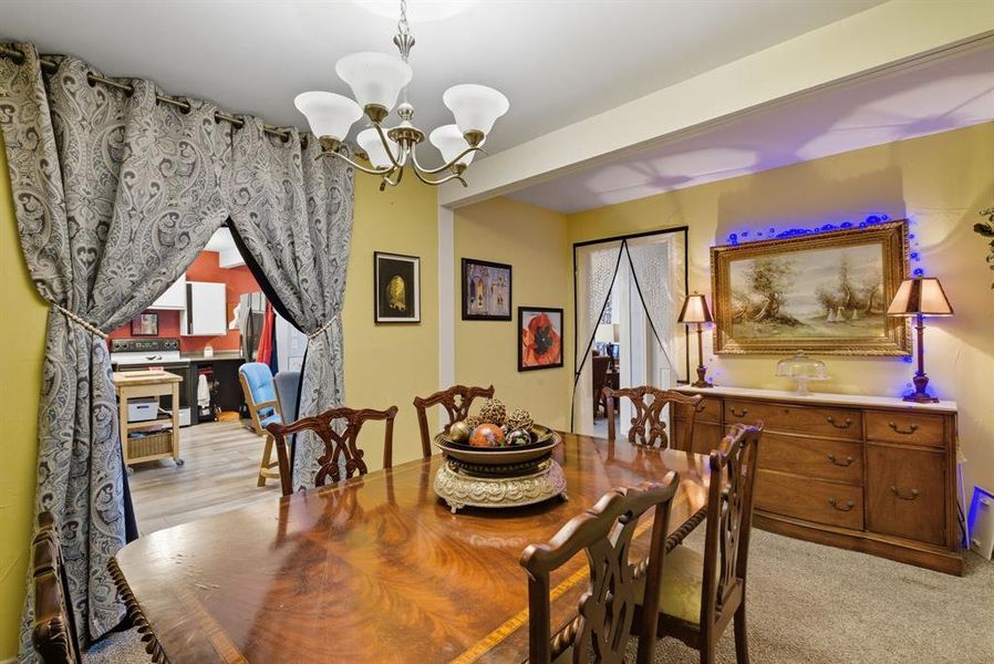 Dining room with a chandelier and light colored carpet Dining room with a chandelier and light colored carpet