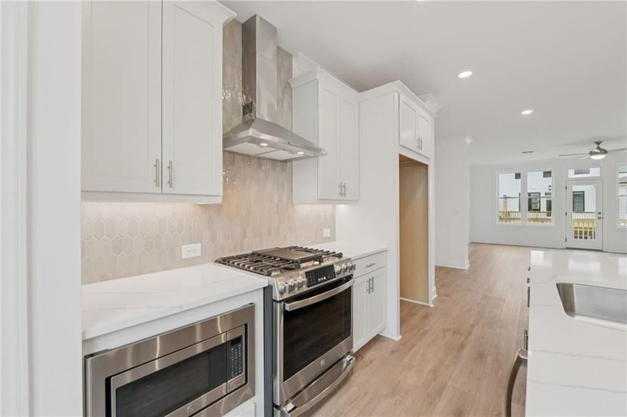 Beautiful Kitchen with GE stainless steel appliances, tile backsplash, quartz kitchen countertops, hard surface flooring, 42" upper kitchen cabinets - soft close