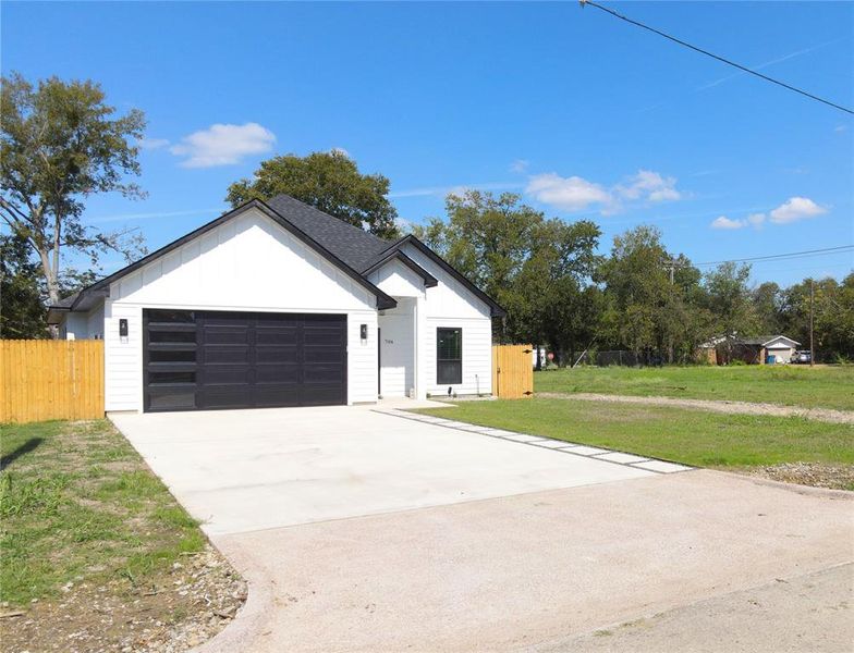 Modern farmhouse featuring board and batten siding, concrete driveway, an attached garage, and a shingled roof Modern farmhouse featuring board and batten siding, concrete driveway, an attached garage, and a shingled roof