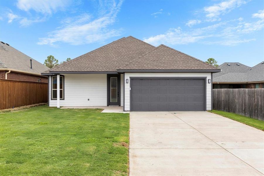 Ranch-style house with a front yard and a garage