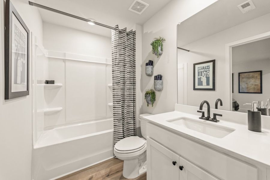 A bathroom with a tub sink and toilet.
