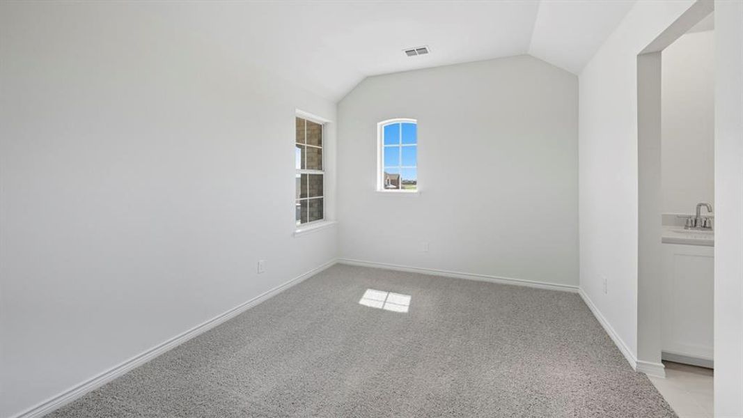 Spare room featuring light colored carpet and lofted ceiling Spare room featuring light colored carpet and lofted ceiling