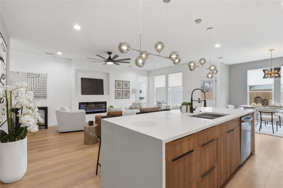 Kitchen with wood finish cabinetry, a kitchen island with sink, light wood-type flooring, modern cabinets, and suspended lighting Kitchen with wood finish cabinetry, a kitchen island with sink, light wood-type flooring, modern cabinets, and suspended lighting