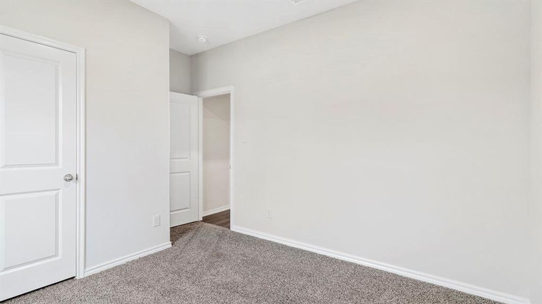 Neutral-toned room featuring a gray carpet and white baseboards