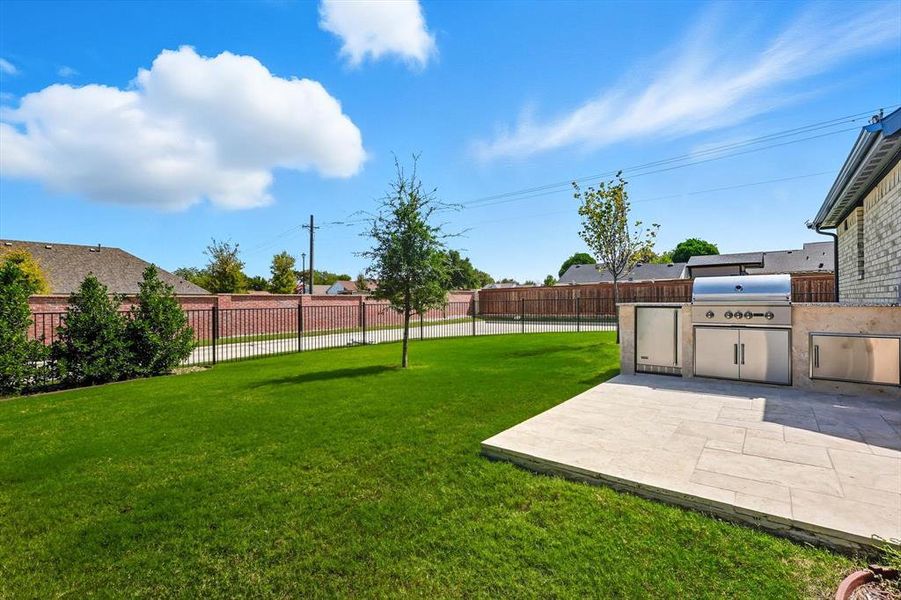 Fenced backyard featuring area for grilling and a patio area