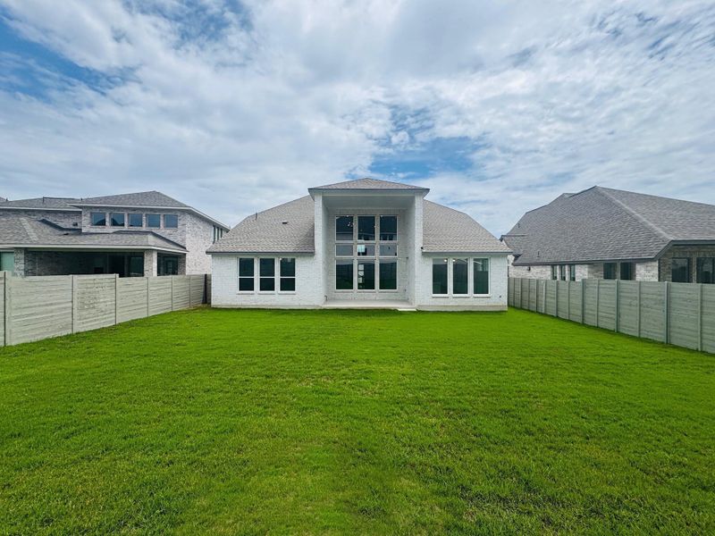 Back of house with a fenced backyard and roof with shingles Back of house with a fenced backyard and roof with shingles