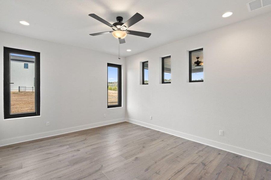 Spare room with light wood-type flooring, a ceiling fan, and recessed lighting