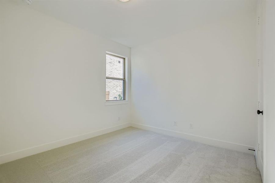 Empty room featuring light colored carpet and baseboards Empty room featuring light colored carpet and baseboards