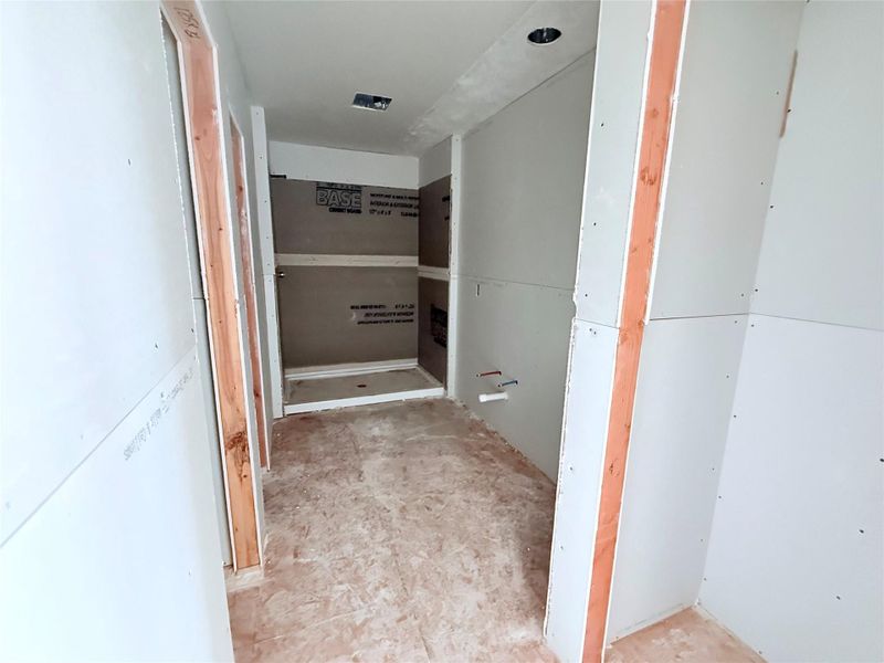 Primary bathroom with double sink vanity, walk in shower and walk in closet