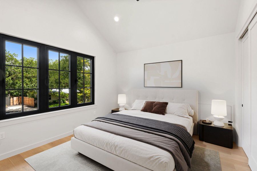 Natural light pours into this bedroom through large windows, highlighting the high vaulted ceilings. Natural light pours into this bedroom through large windows, highlighting the high vaulted ceilings.
