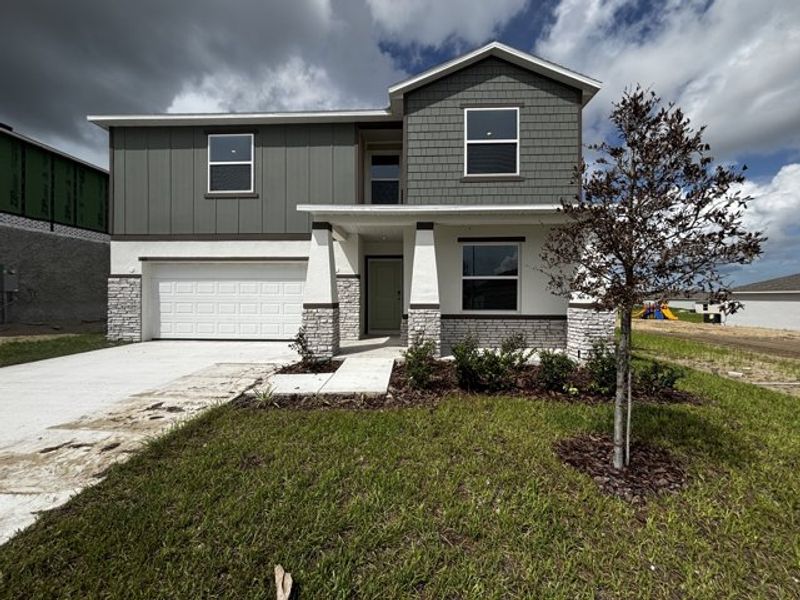 Front exterior of a new home in Woodland Ranch, Dundee, FL, highlighting curb appeal (Image 1). Front exterior of a new home in Woodland Ranch, Dundee, FL, highlighting curb appeal (Image 1).