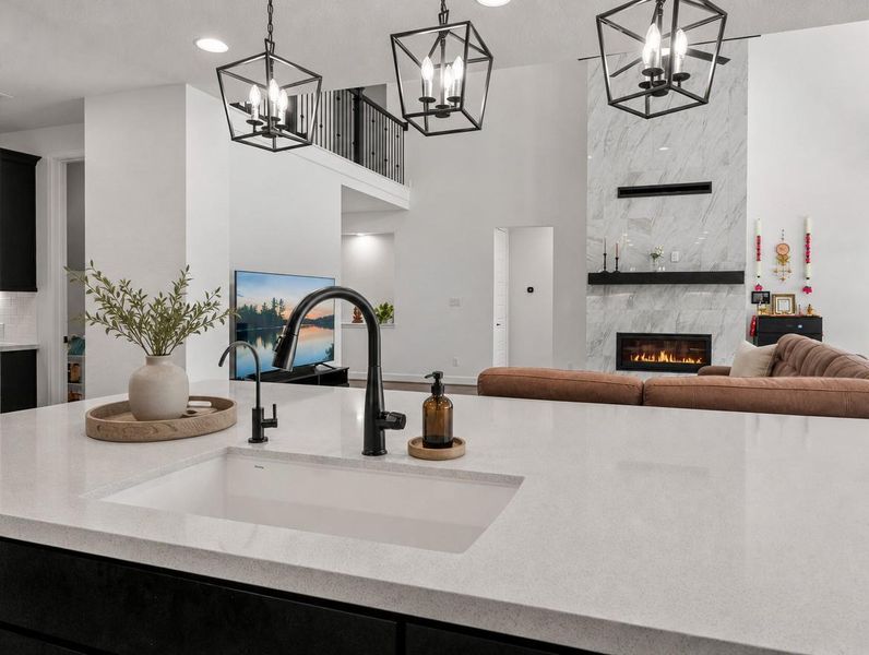 An open-concept living space features soaring ceilings and a contemporary fireplace. An open-concept living space features soaring ceilings and a contemporary fireplace.
