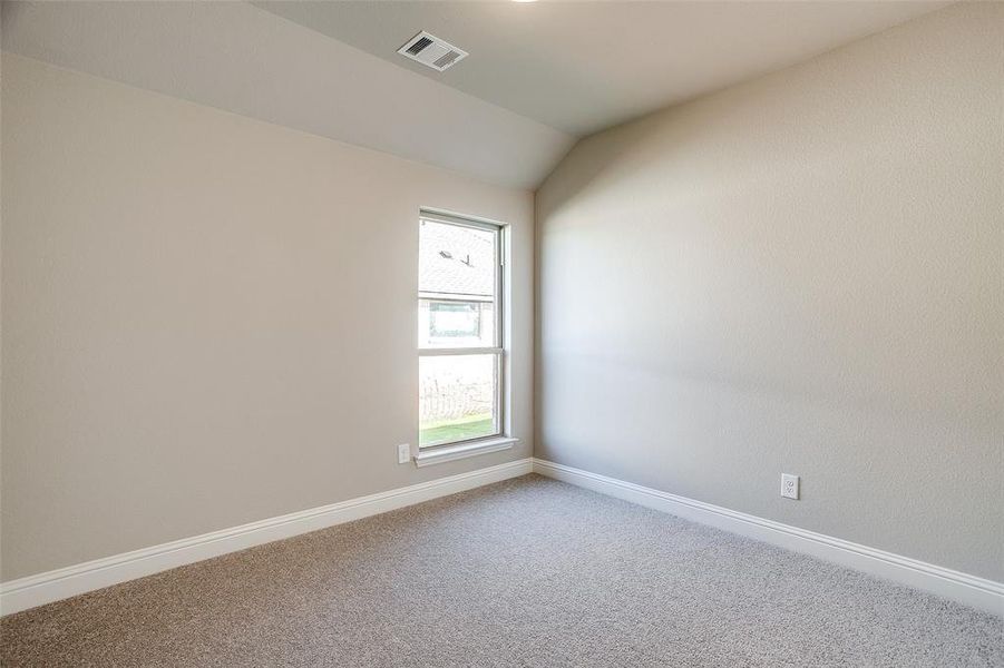 Unfurnished room featuring lofted ceiling and carpet Unfurnished room featuring lofted ceiling and carpet