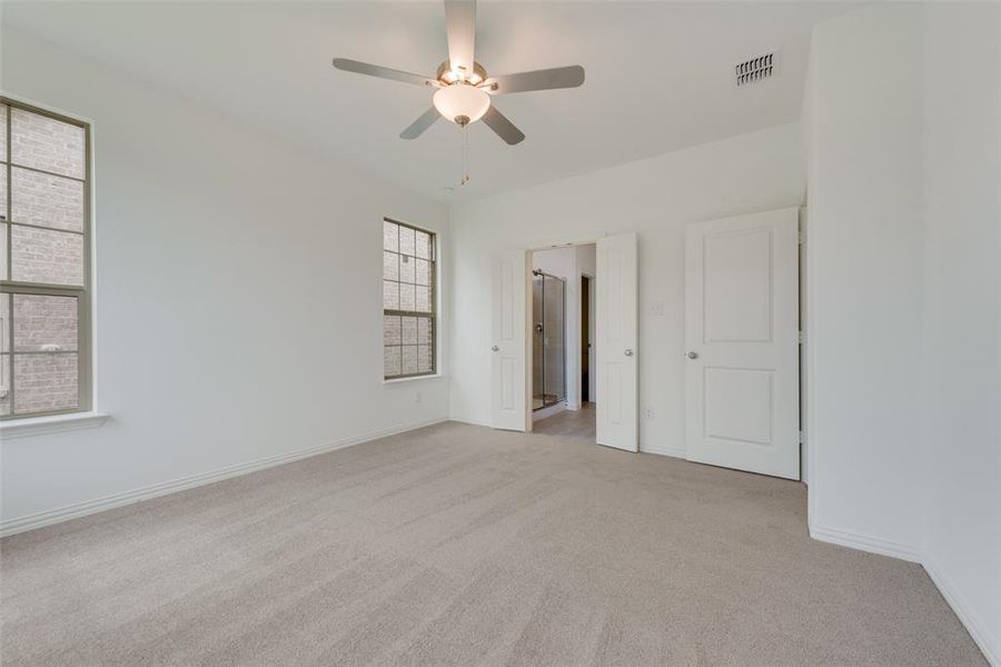 Carpeted empty room featuring ceiling fan