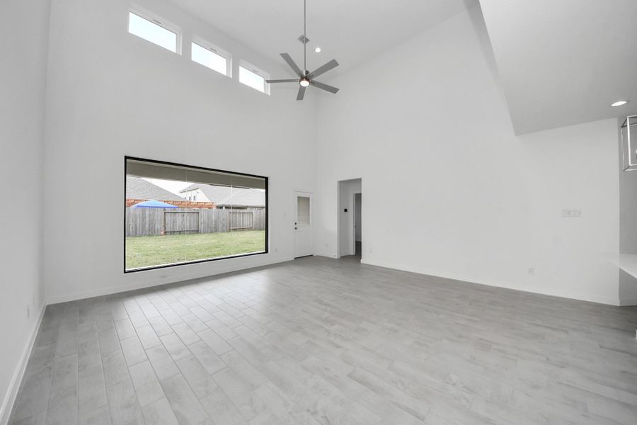 Welcome family and guests to your charming living room! With its high ceilings, recessed lighting, ceiling fan, custom paint, beautiful flooring, and large windows that let in abundant natural light, this room is perfect for gatherings. Sample photo of completed home with similar floor plan. Actual colors and selections may vary. Welcome family and guests to your charming living room! With its high ceilings, recessed lighting, ceiling fan, custom paint, beautiful flooring, and large windows that let in abundant natural light, this room is perfect for gatherings. Sample photo of completed home with similar floor plan. Actual colors and selections may vary.