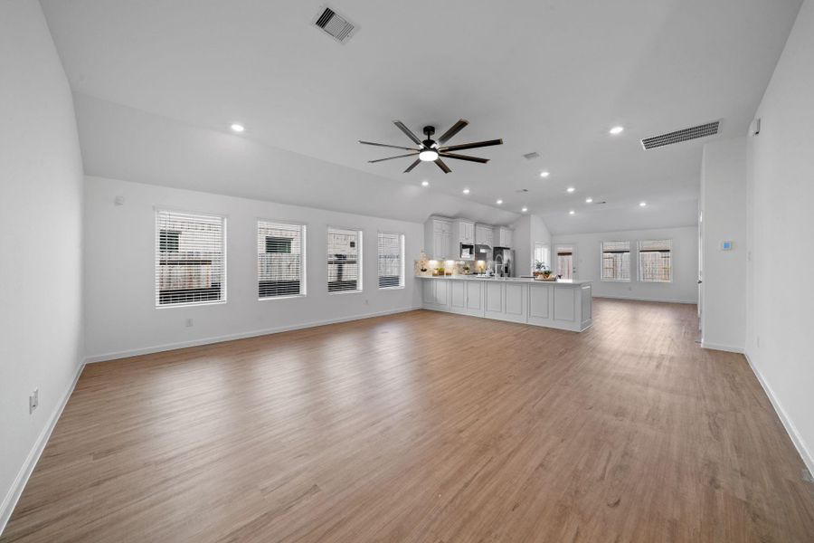 This wide-open living room flows seamlessly into the kitchen, creating the kind of layout that brings everyone together, whether you’re hosting a holiday crowd or enjoying a quiet morning with sunlight pouring through the wall of windows.