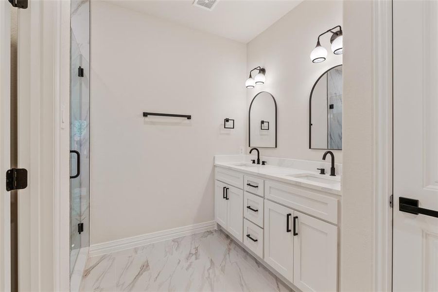 Bathroom featuring a shower with door and vanity