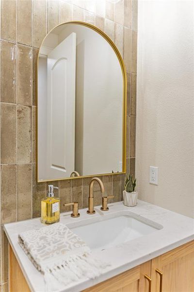 Bathroom featuring vanity and tasteful backsplash