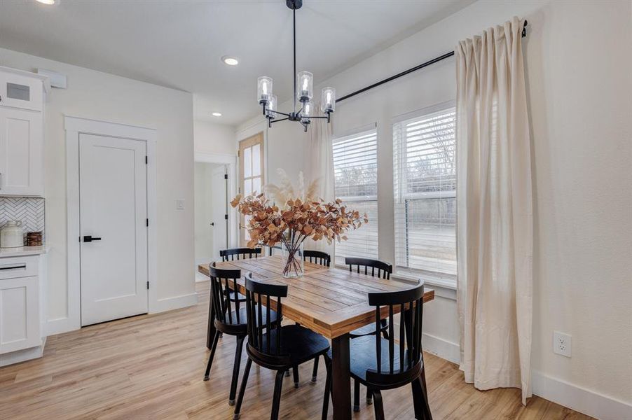 Dining area featuring a chandelier, light wood-type flooring, and recessed lighting Dining area featuring a chandelier, light wood-type flooring, and recessed lighting