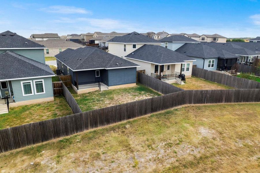 Back of house with a patio, a residential view, roof with shingles, and a fenced backyard