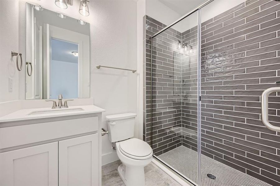 Full bath featuring a shower stall, vanity, and toilet Full bath featuring a shower stall, vanity, and toilet